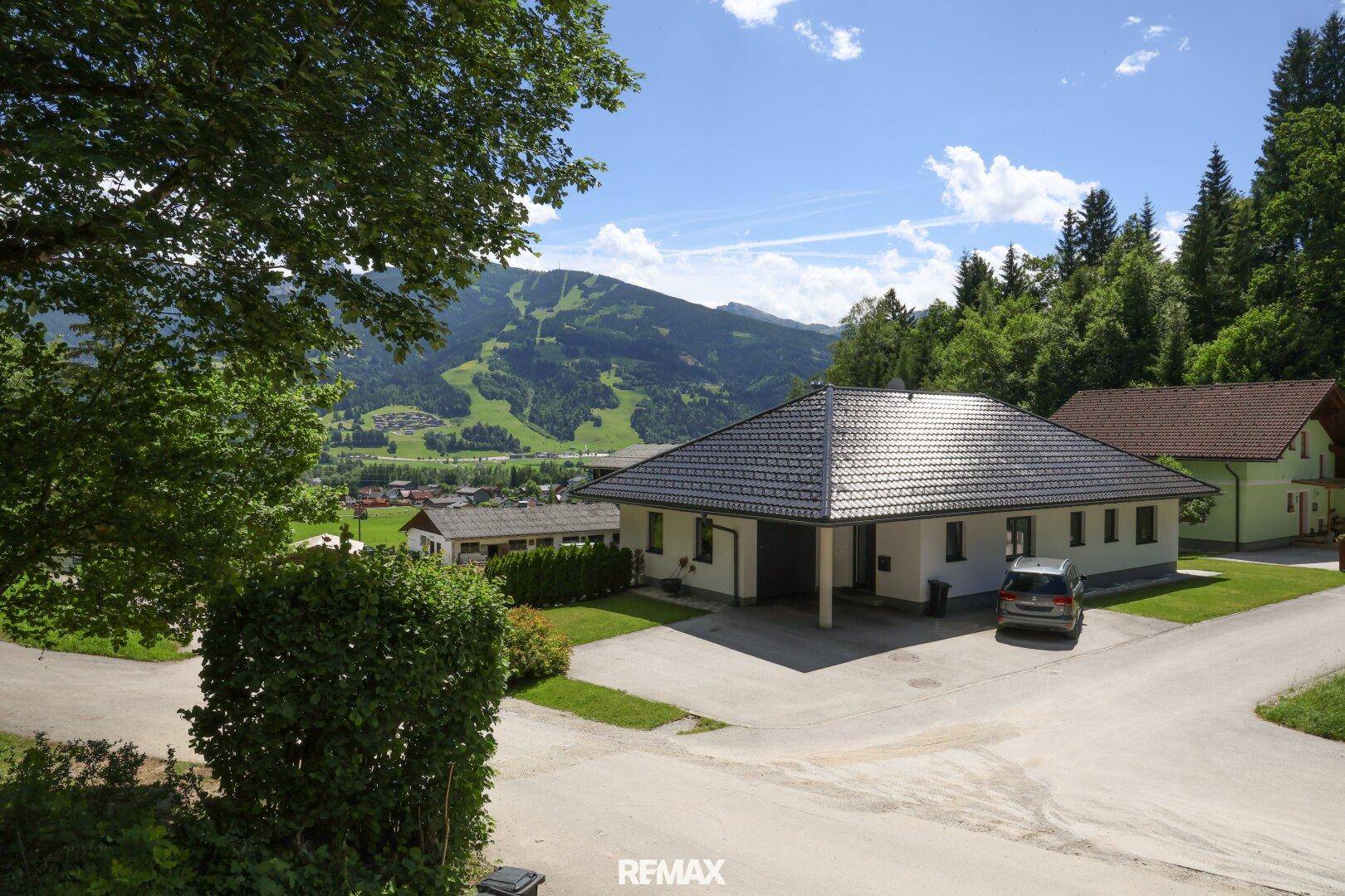 Weitläufiges Grundstück mit Einfamilienhaus, großer Auffahrt und beeindruckendem Bergblick.