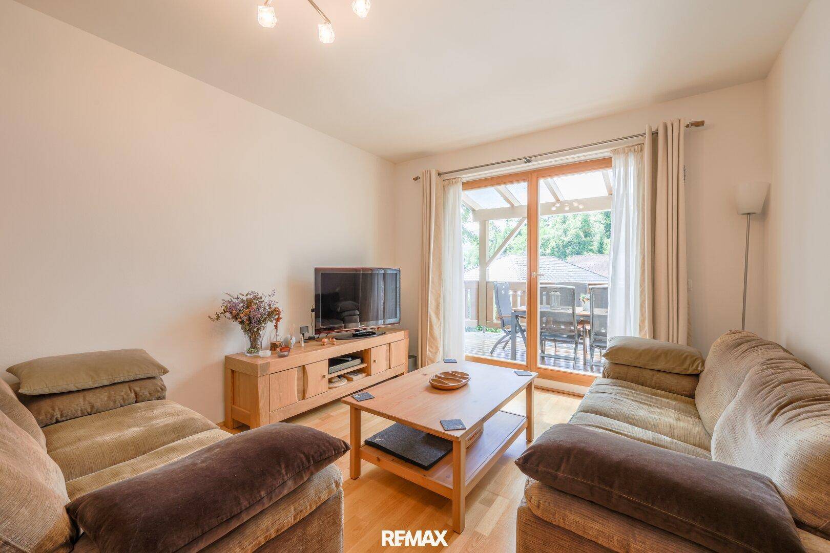 Gemütlicher Wohnbereich mit bequemen Sofas, Holzboden und direktem Zugang zur Terrasse.