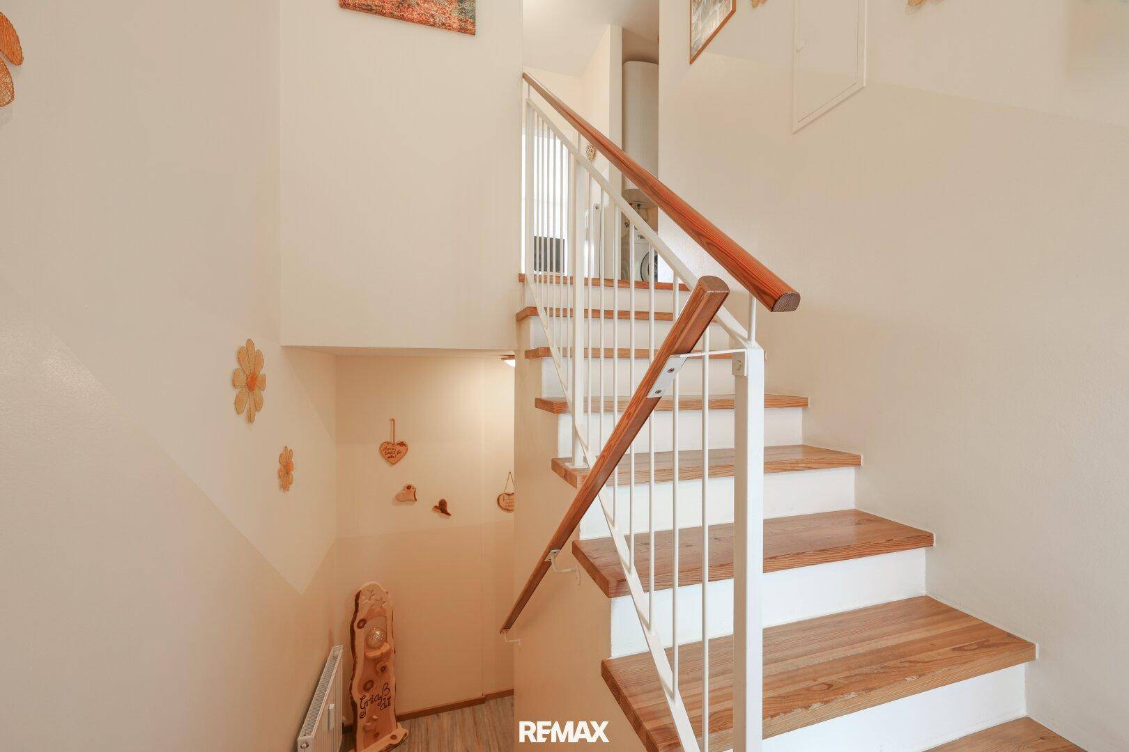 Holztreppe mit weißem Geländer, die die verschiedenen Ebenen des Hauses verbindet.