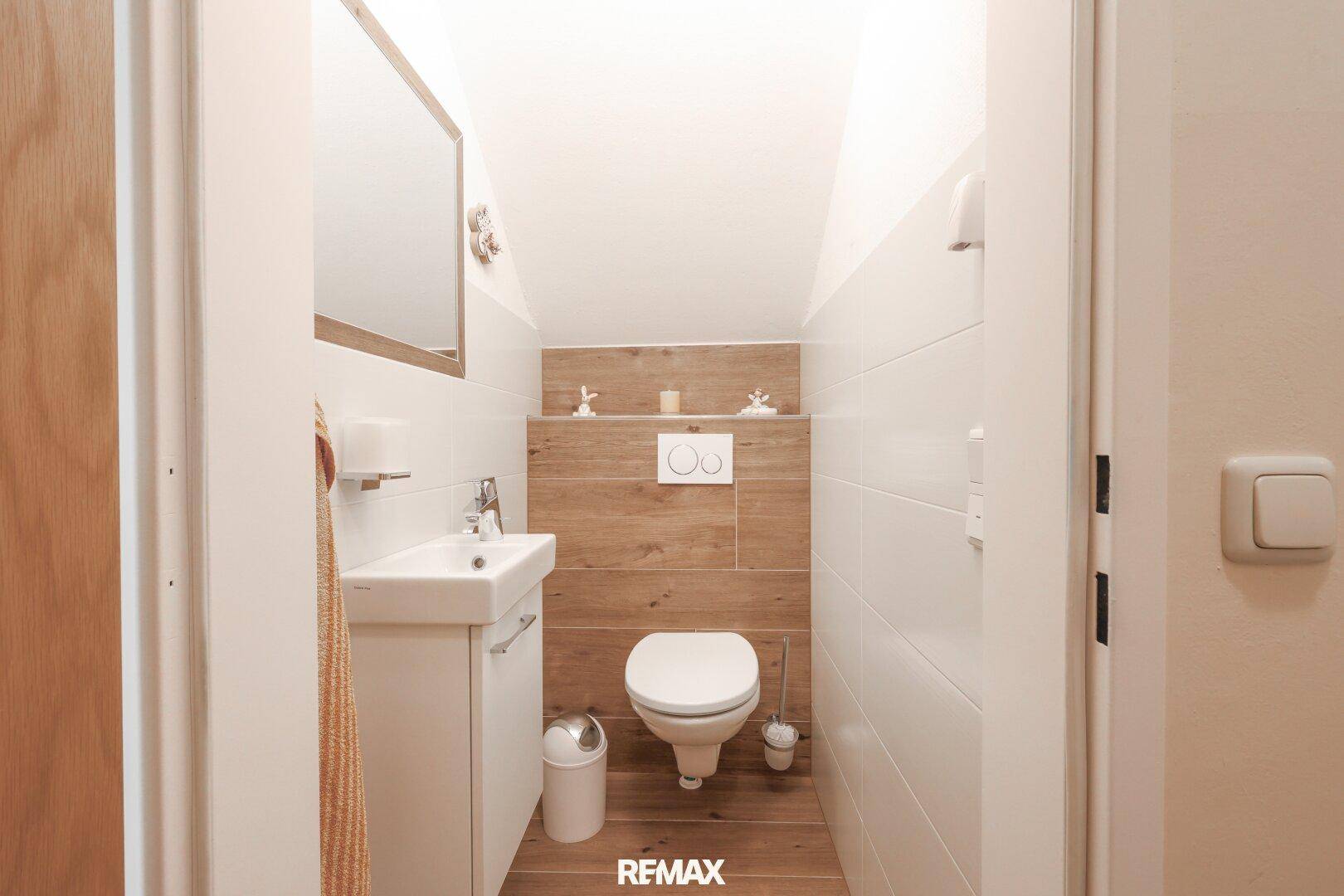 Kleines Gäste-WC mit modernem Design, Wand-WC und Waschbecken.