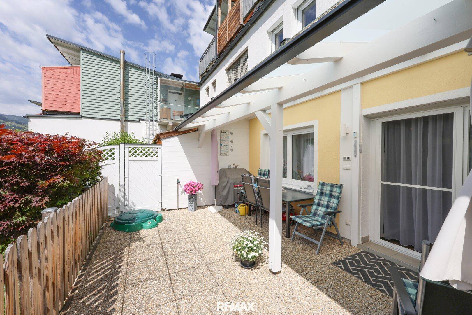 Gepflasterte Terrasse mit Sitzgelegenheiten und Sichtschutz, direkt am Haus gelegen.