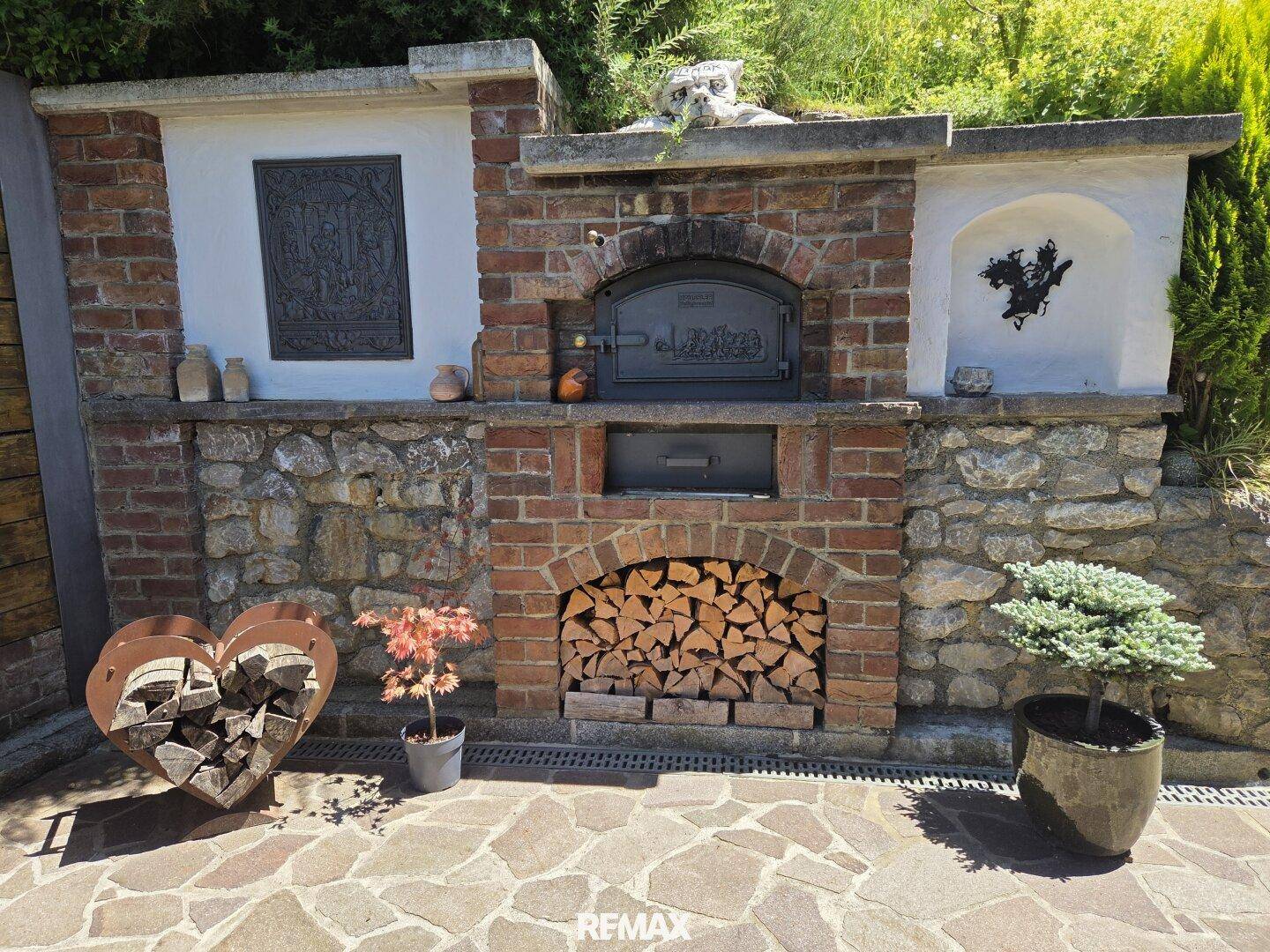 Rustikaler Außenbackofen aus Ziegelstein mit Holzfach, ideal für gesellige Abende im Garten.