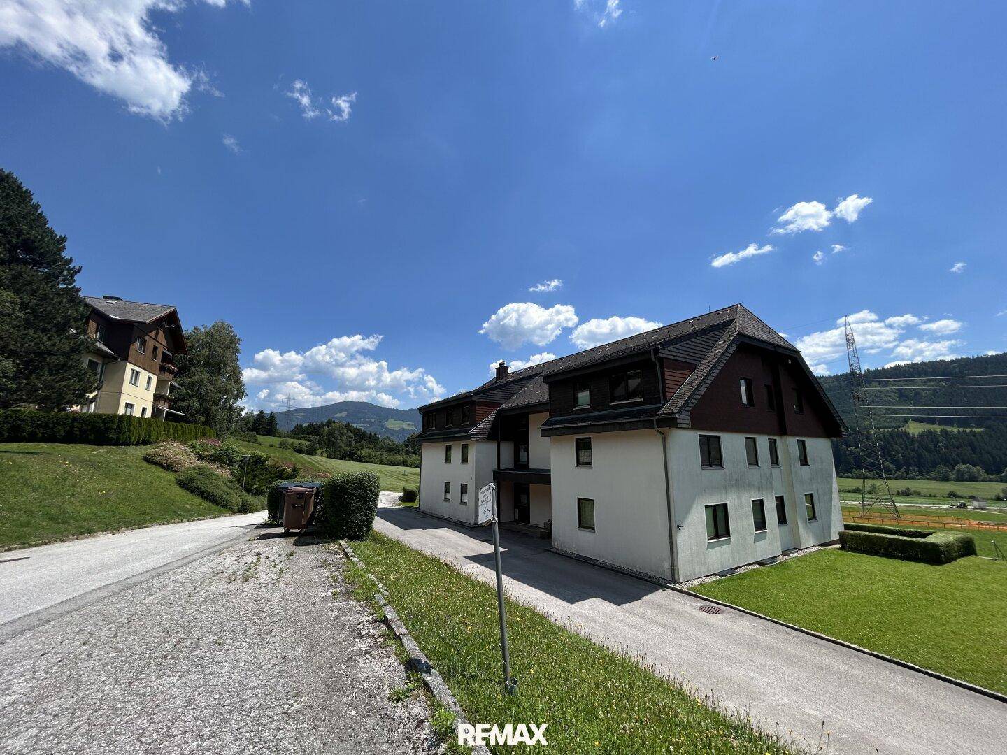 Wohnhaus in ländlicher Umgebung mit Zufahrt und weitem Blick auf die Landschaft.