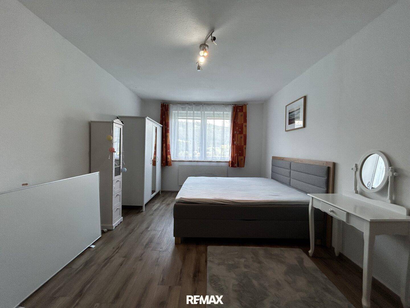 Geräumiges Schlafzimmer mit Doppelbett, Kleiderschränken und Schminktisch.