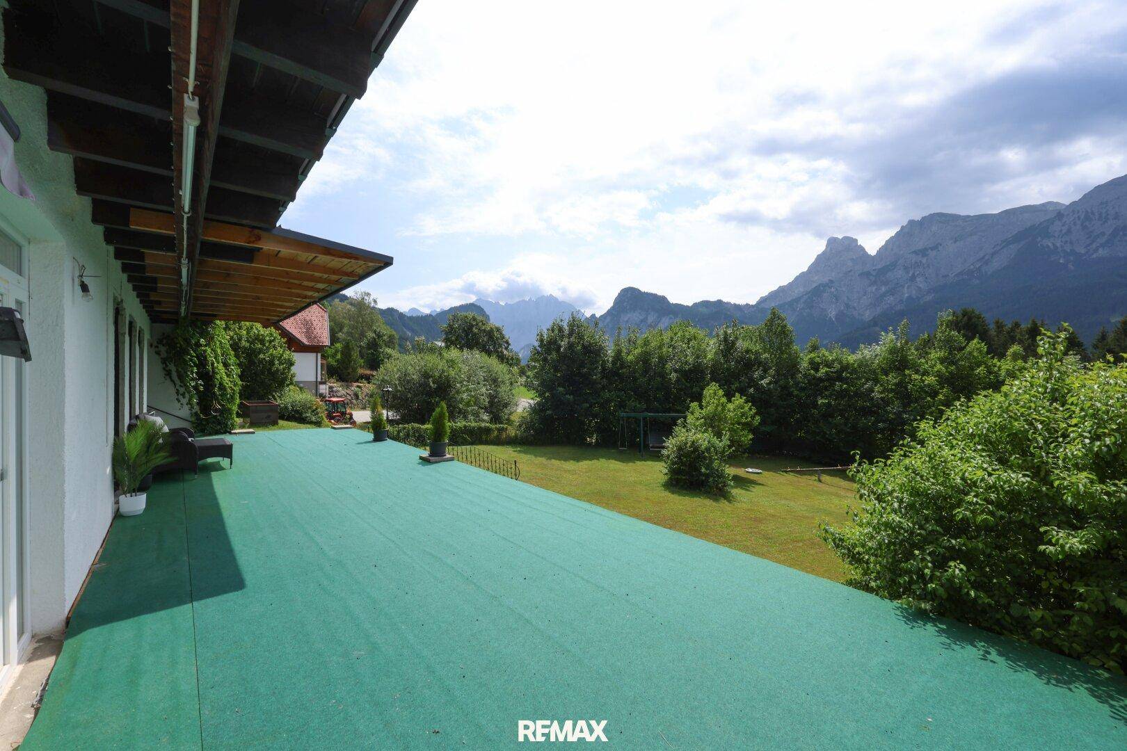 Große Terrasse mit Kunstrasen und weitem Panoramablick auf die umliegende Berglandschaft.