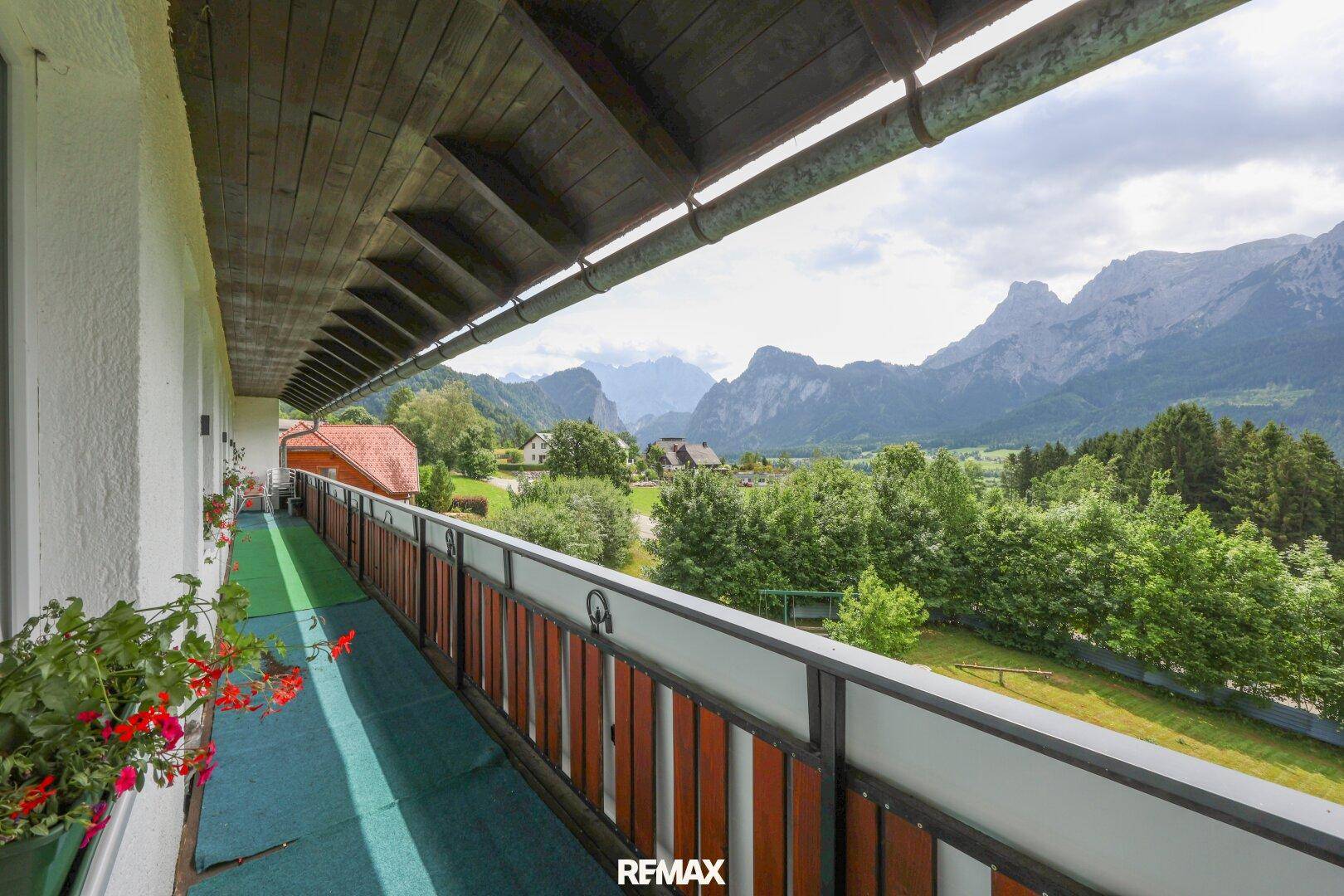 Langer Balkon mit Holzboden und atemberaubendem Blick auf die majestätische Bergwelt.