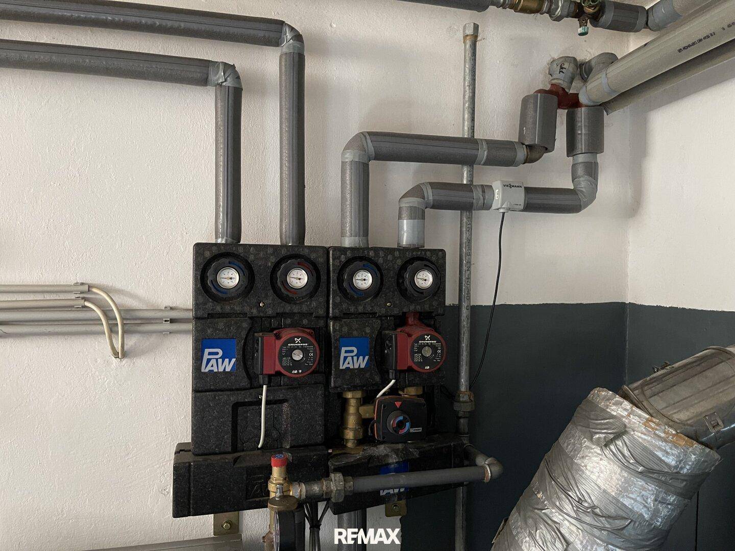 Detailansicht der Heizungsanlage mit Pumpen und Steuerungselementen im Keller.