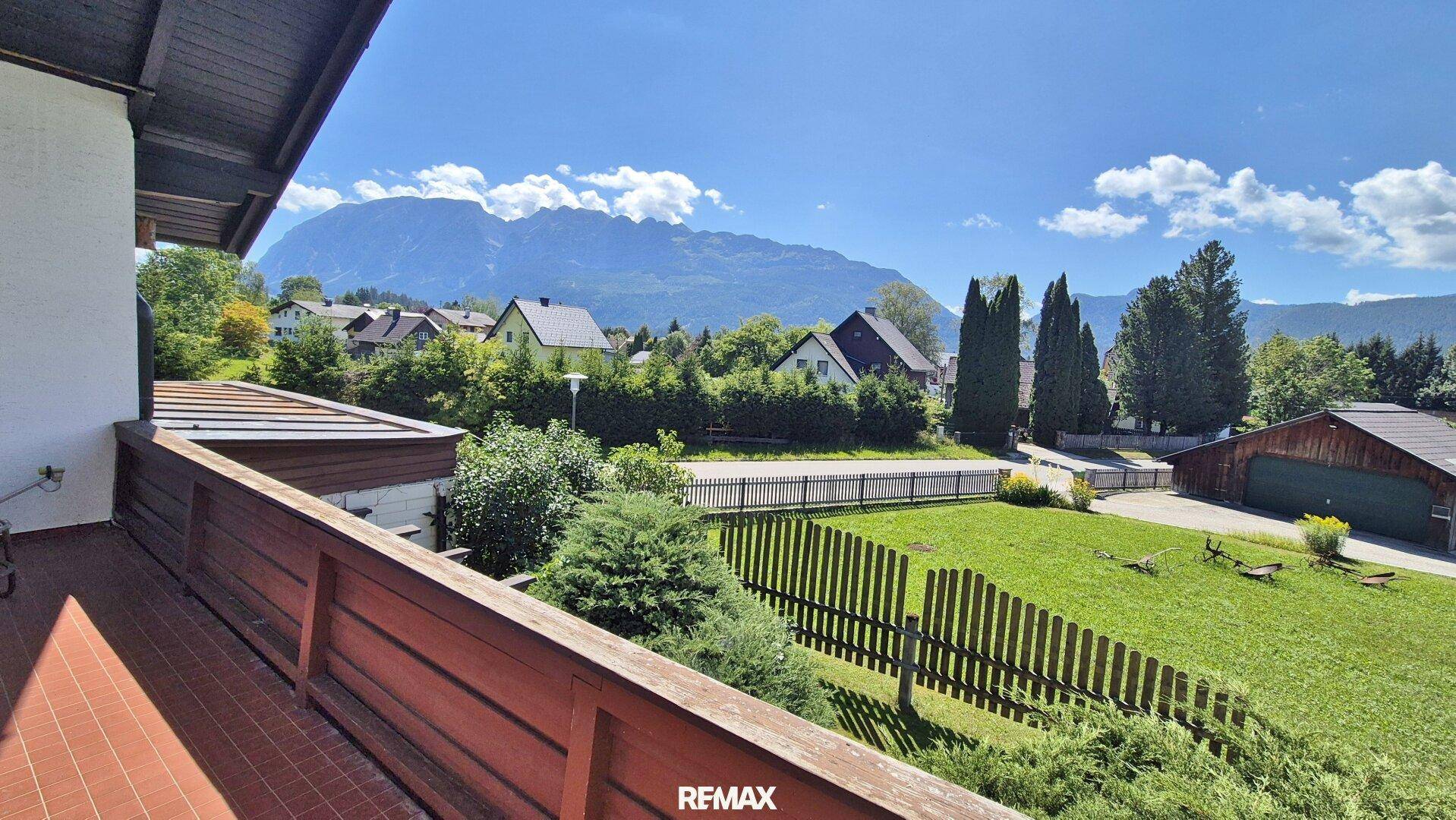 Großer Balkon mit Holzboden und Geländer, bietet einen weiten Blick auf die Berge und Umgebung.