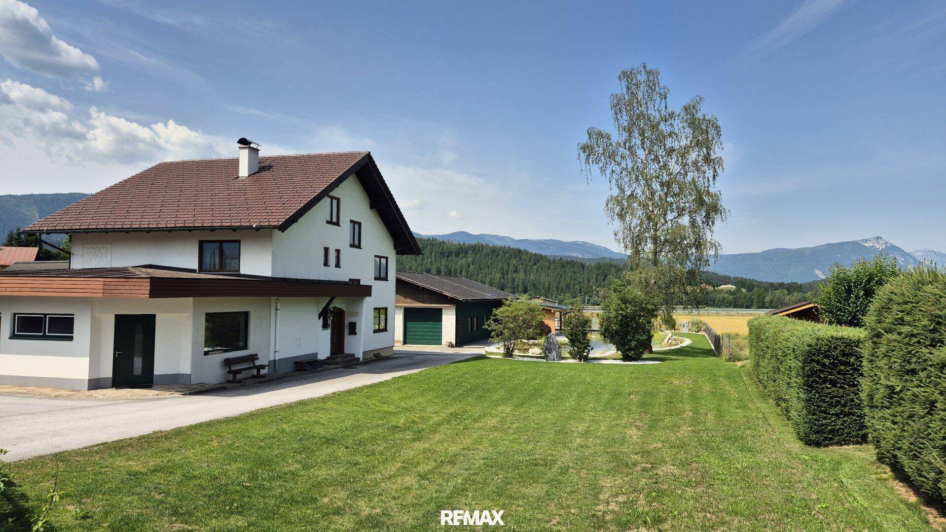 Freistehendes Haus mit Satteldach und großem Vorgarten, umgeben von ländlicher Landschaft.
