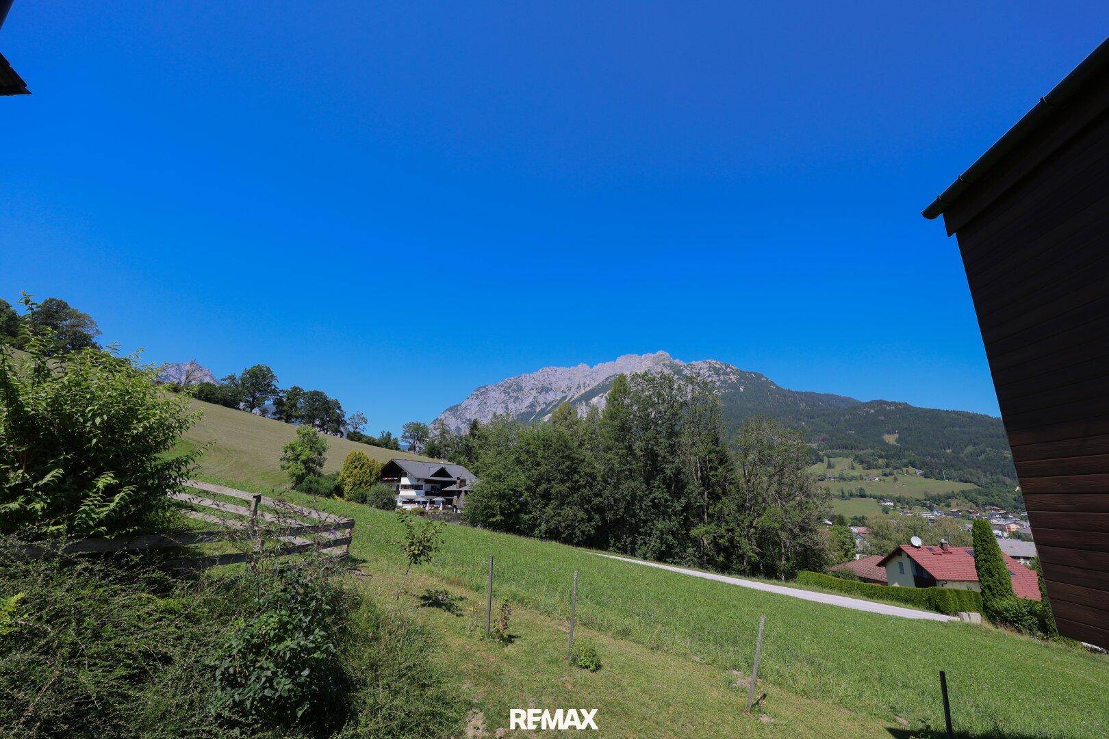 Weitläufiger Blick auf die grüne Landschaft und die majestätischen Berge.