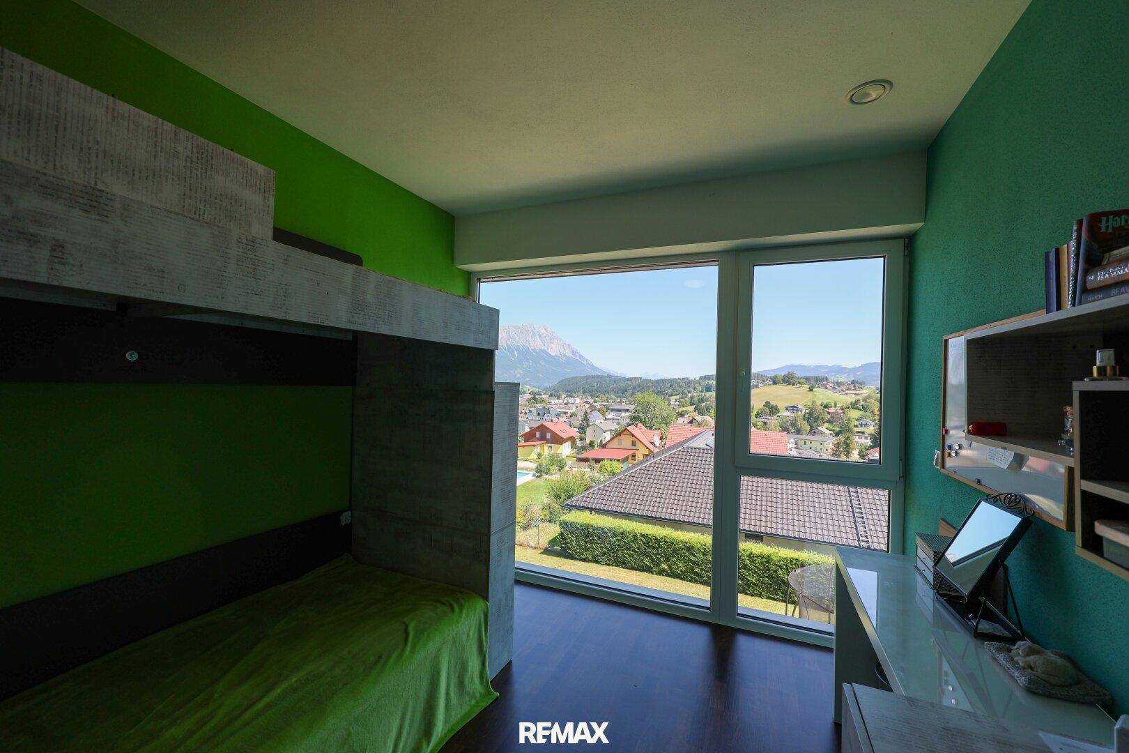 Kinderzimmer mit Etagenbett, grünen Wänden und weitem Ausblick.