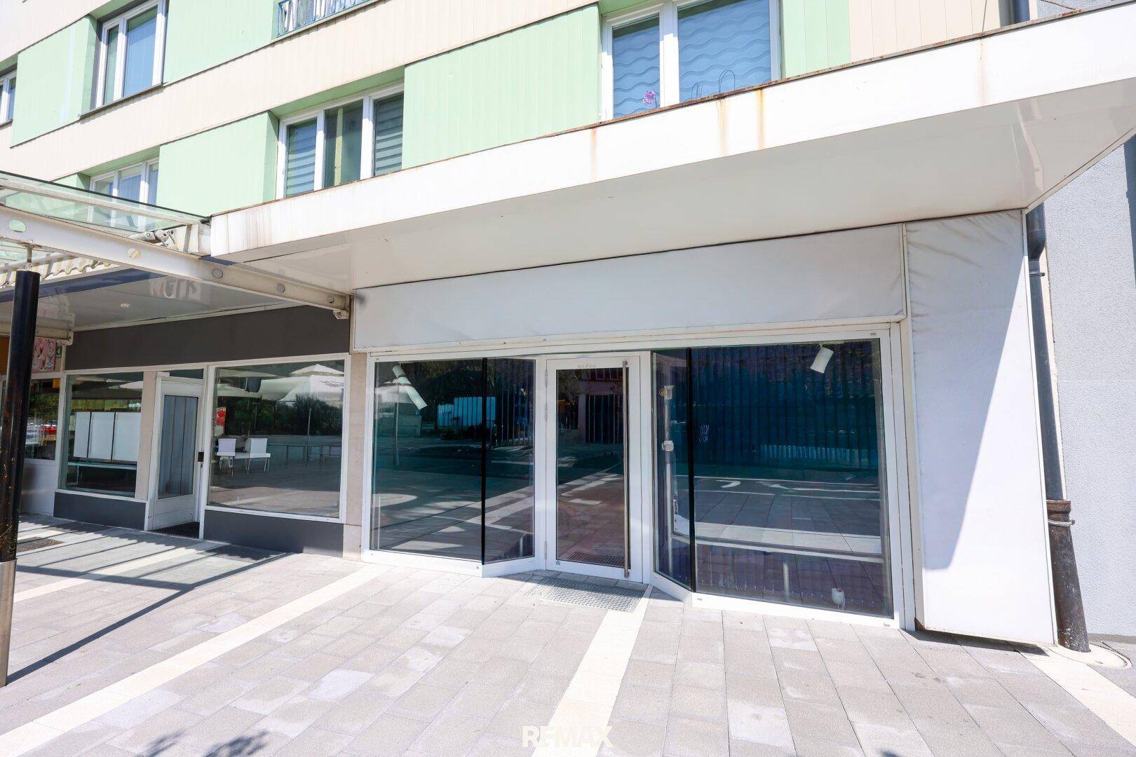 Nahaufnahme der Geschäftsfassade mit großen Glasfenstern und einem Vordach, bereit zur Vermietung.