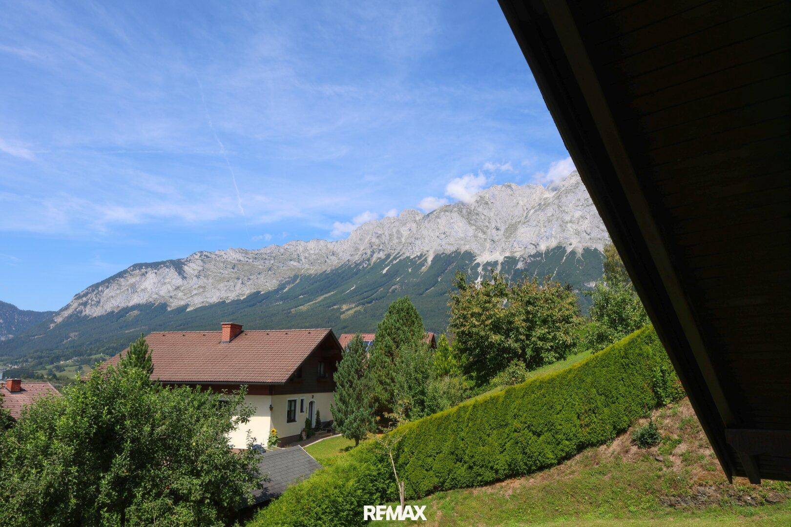 Weitläufiger Blick auf die majestätische Bergkette und die grüne Landschaft.