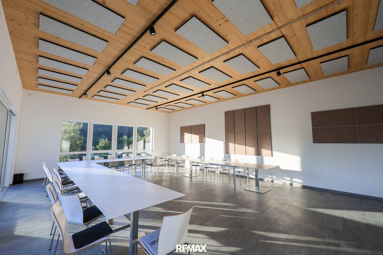 Geräumiger Konferenzraum mit Holzbalkendecke und Schallschutz, ideal für Besprechungen und Veranstaltungen.