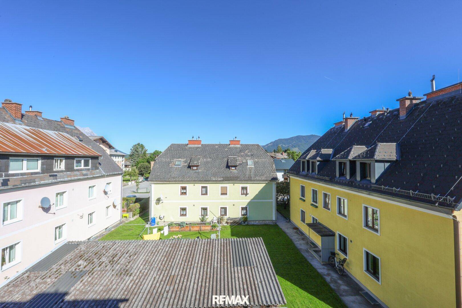 Blick von oben auf mehrere Wohngebäude und einen gepflegten Gemeinschaftsgarten.