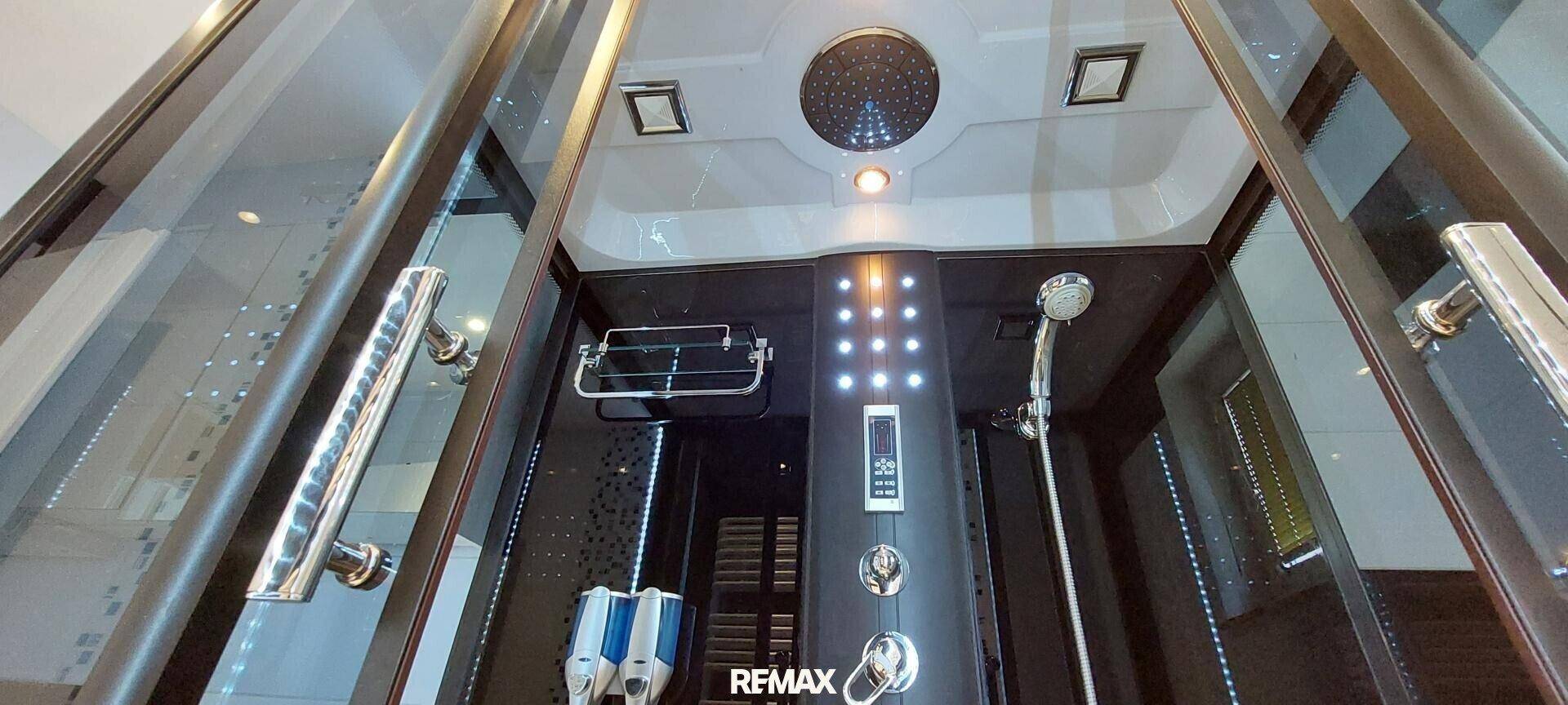 Detailansicht einer modernen Duschkabine mit Regendusche und Massagedüsen.