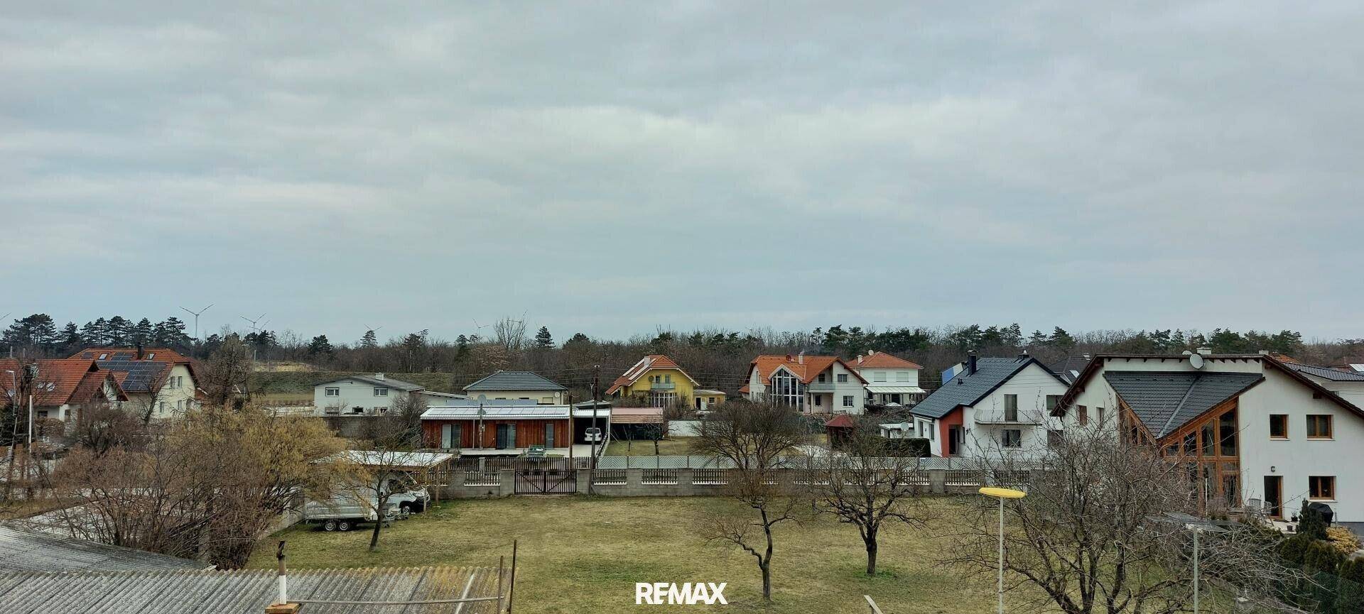 Panoramablick über eine ländliche Wohnsiedlung mit viel Grün.