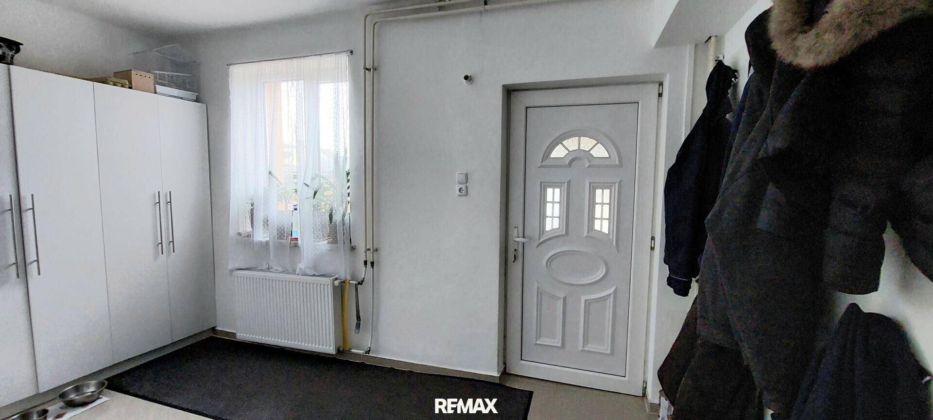 Heller Eingangsbereich mit praktischer Garderobe, Einbauschränken und Fenster für Tageslicht.