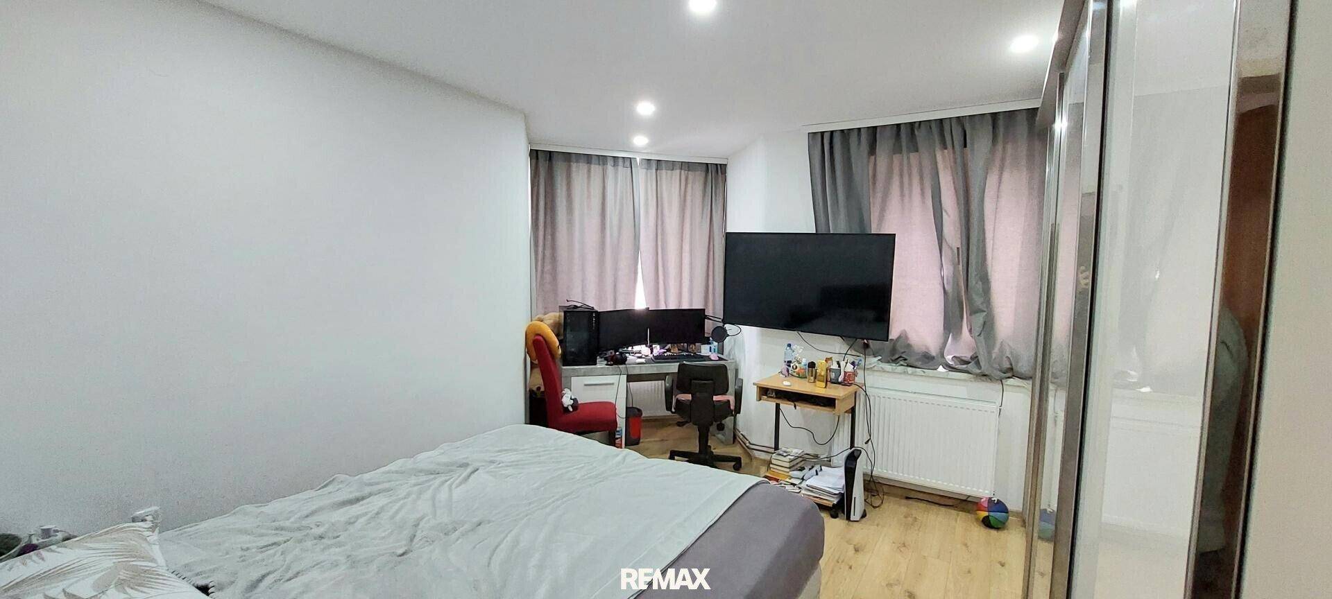 Funktionales Schlafzimmer mit Bett, Schreibtisch und Computerausstattung, ideal für Home-Office.