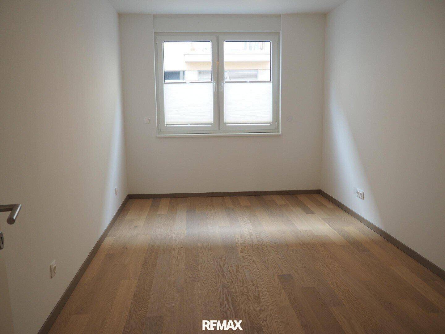 Ruhiges Schlafzimmer mit Holzboden und Fenster, bietet eine angenehme Atmosphäre.