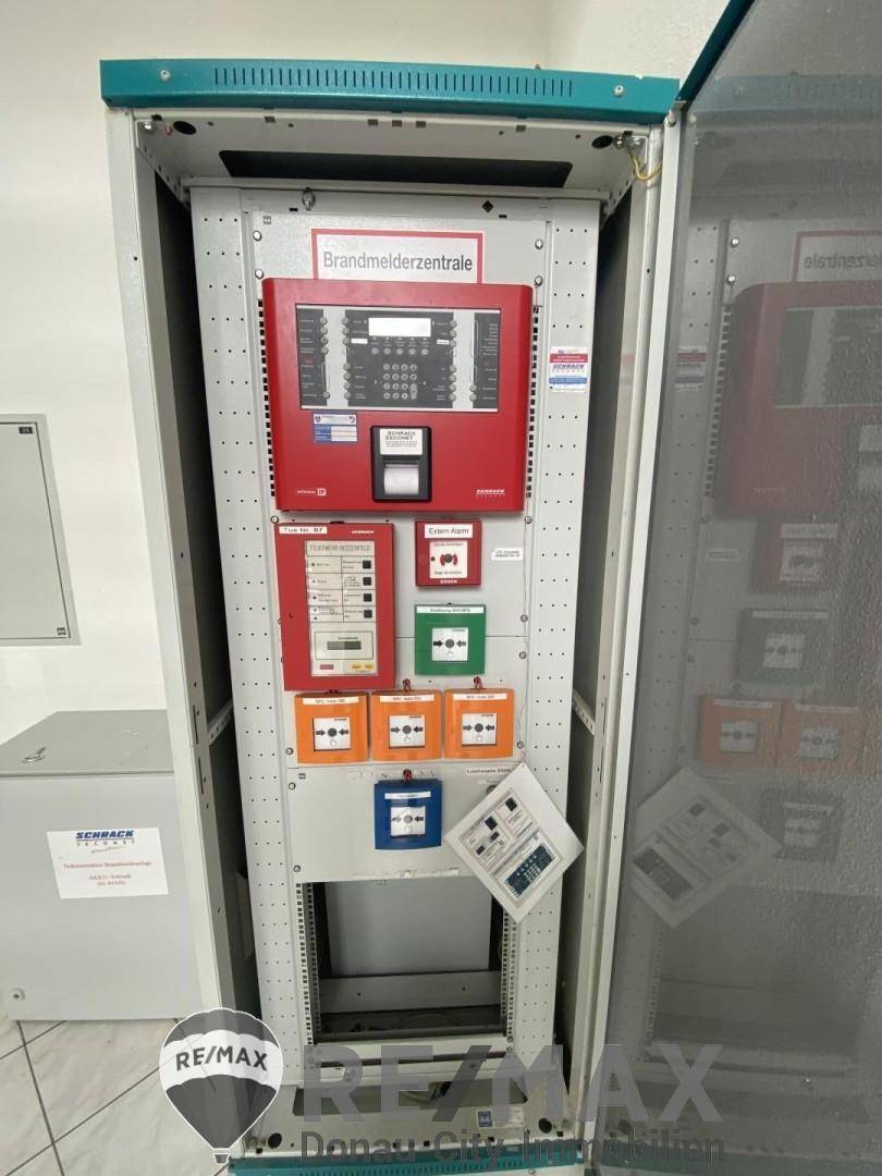 Detailansicht einer Brandmelderzentrale mit verschiedenen Bedienfeldern und Anzeigen in einem Technikraum.