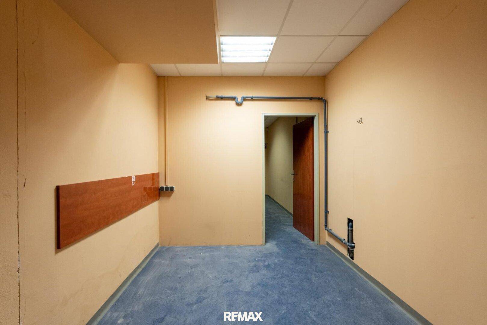Kleiner, leerer Raum mit beigen Wänden und dunklem Boden, geeignet als Abstell- oder Lagerraum.