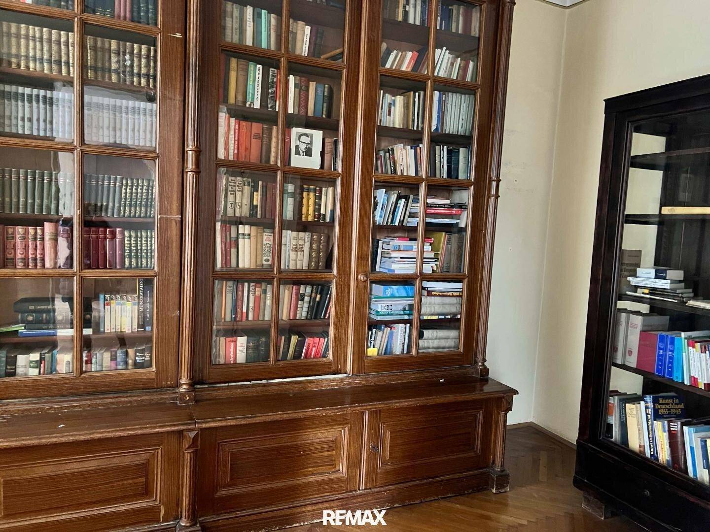Klassische Bibliothek mit hohen, holzvertäfelten Bücherregalen, gefüllt mit Büchern.