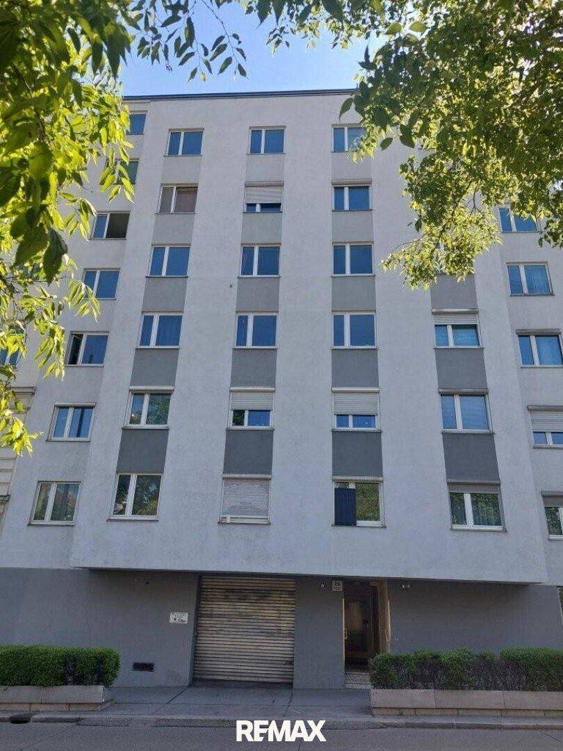 Die moderne Fassade des Mehrfamilienhauses mit zahlreichen Fenstern und grüner Umgebung.