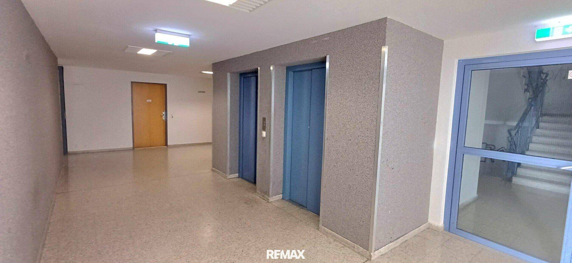 Heller Flur mit zwei Aufzügen und Zugang zum Treppenhaus.