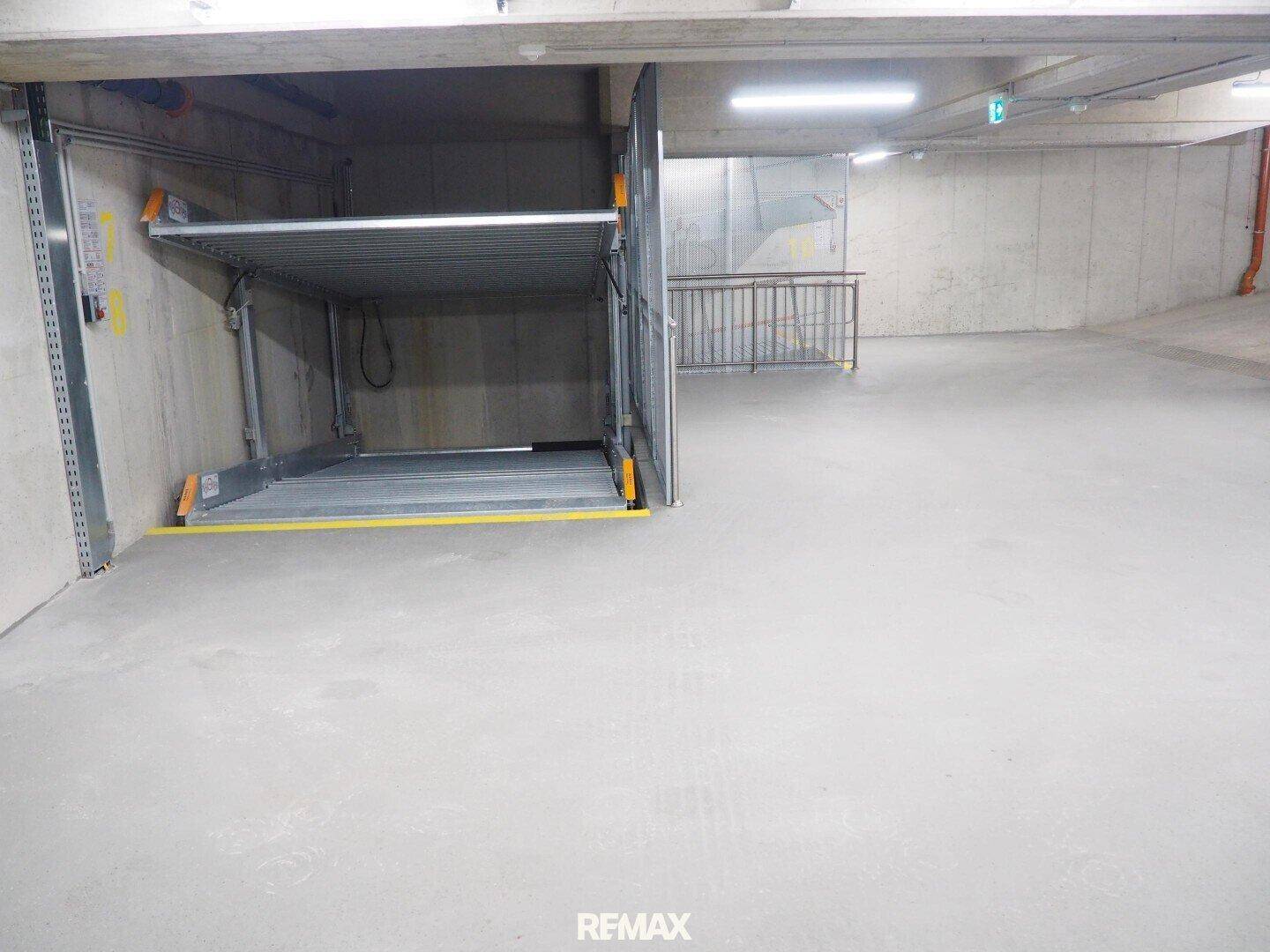 Tiefgarage mit modernem Autoaufzugsystem und ausreichend Platz für Fahrzeuge.