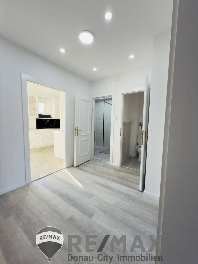 Heller Flur mit Laminatboden, der Zugang zu verschiedenen Räumen bietet.