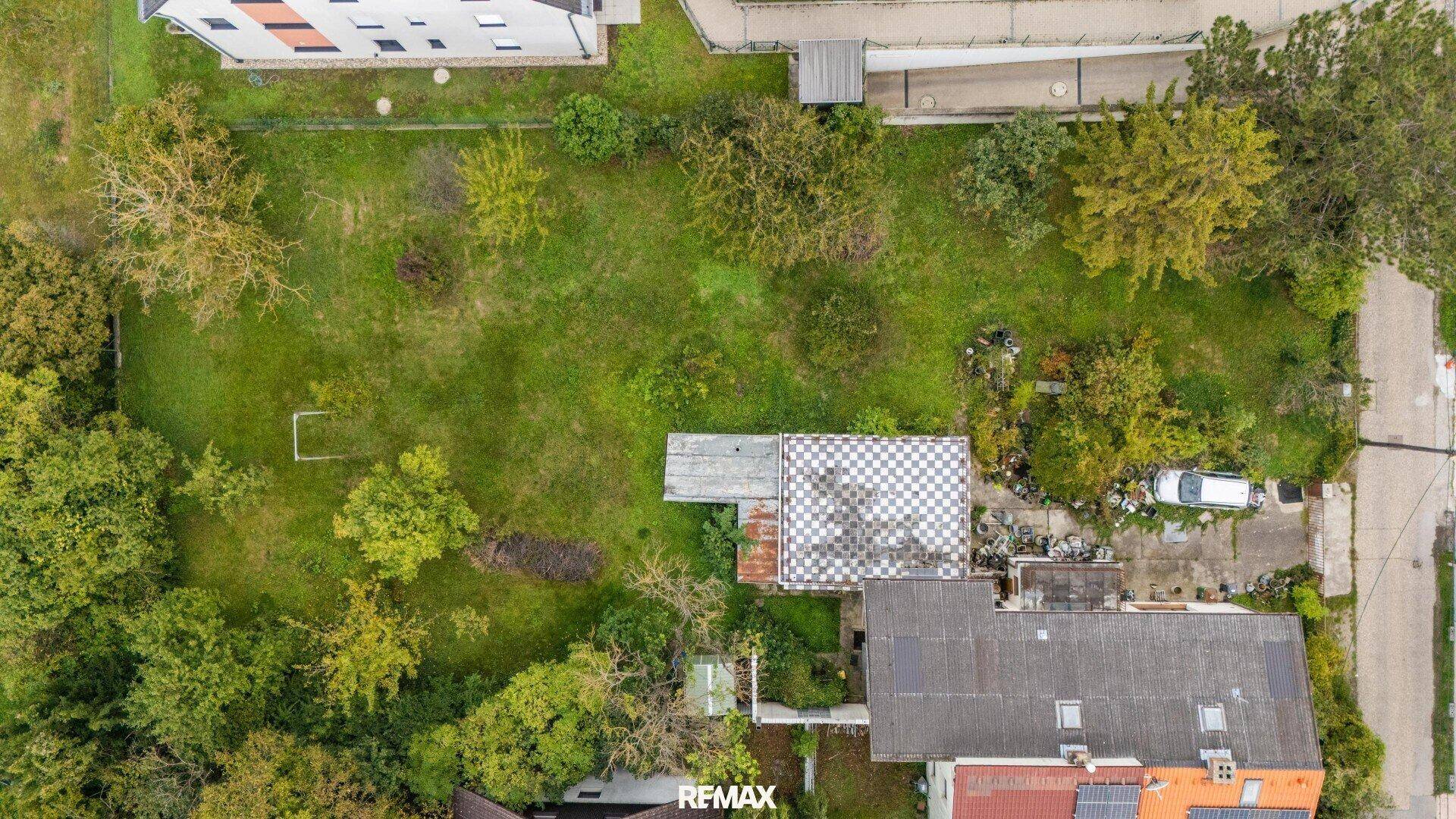 Senkrechte Draufsicht auf das Grundstück mit Haus, Garage und dem weitläufigen grünen Garten.