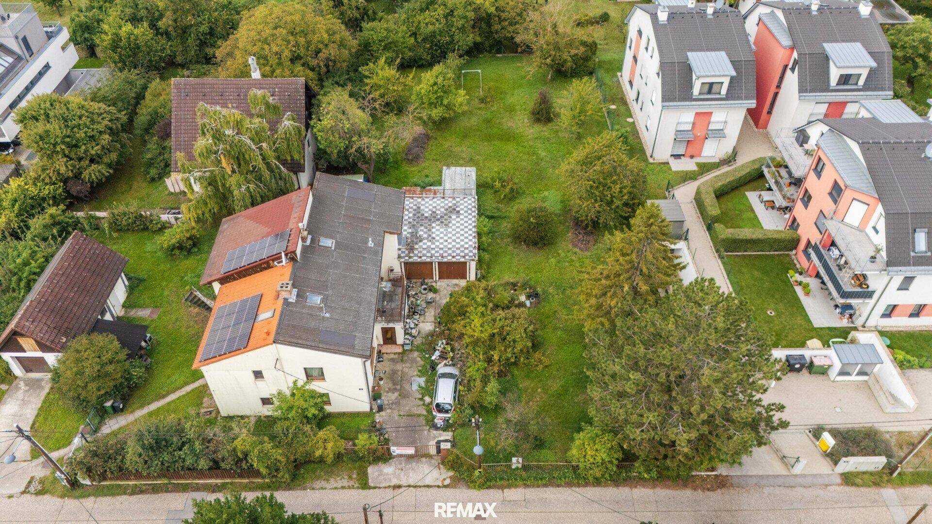 Vogelperspektive des Hauses mit Solaranlagen auf dem Dach und angrenzendem Gartenbereich.