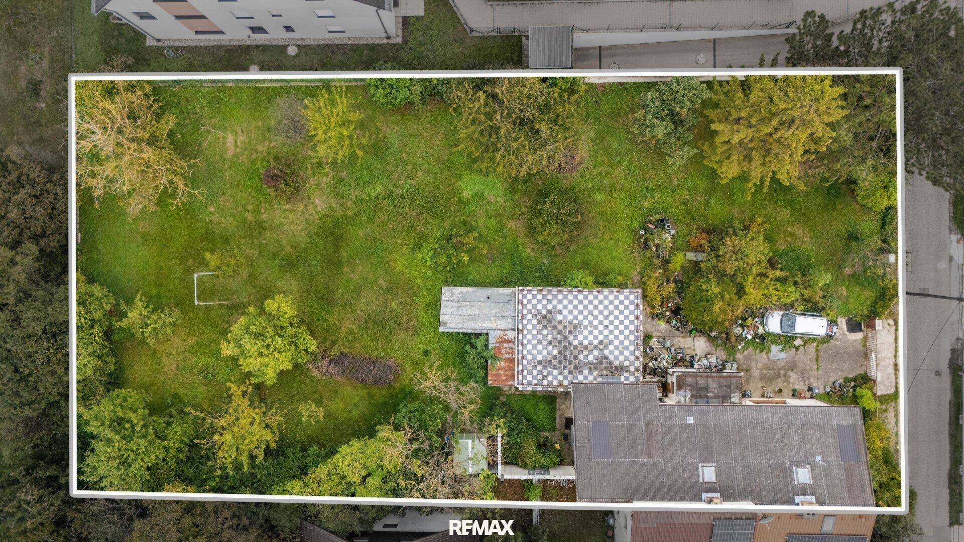 Senkrechte Draufsicht auf das Grundstück mit weißer Umrandung, Haus und Garten.