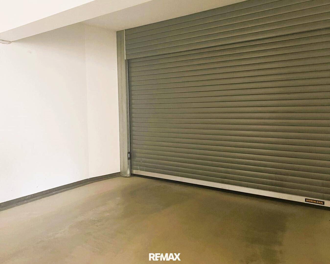 Innenansicht einer Garage mit geschlossenem grauen Rolltor der Marke Hörmann.