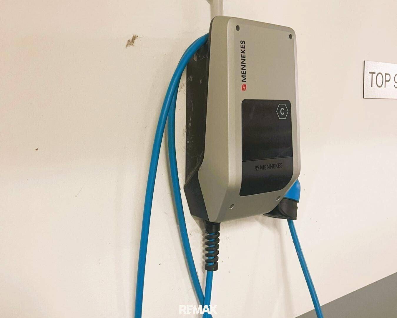 Nahaufnahme einer Mennekes Elektroauto-Ladestation an der Wand in der Tiefgarage.