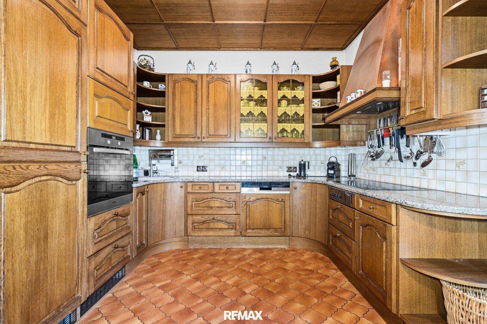Rustikale Küche mit Holzschränken, Granitarbeitsplatten und integrierten Geräten.