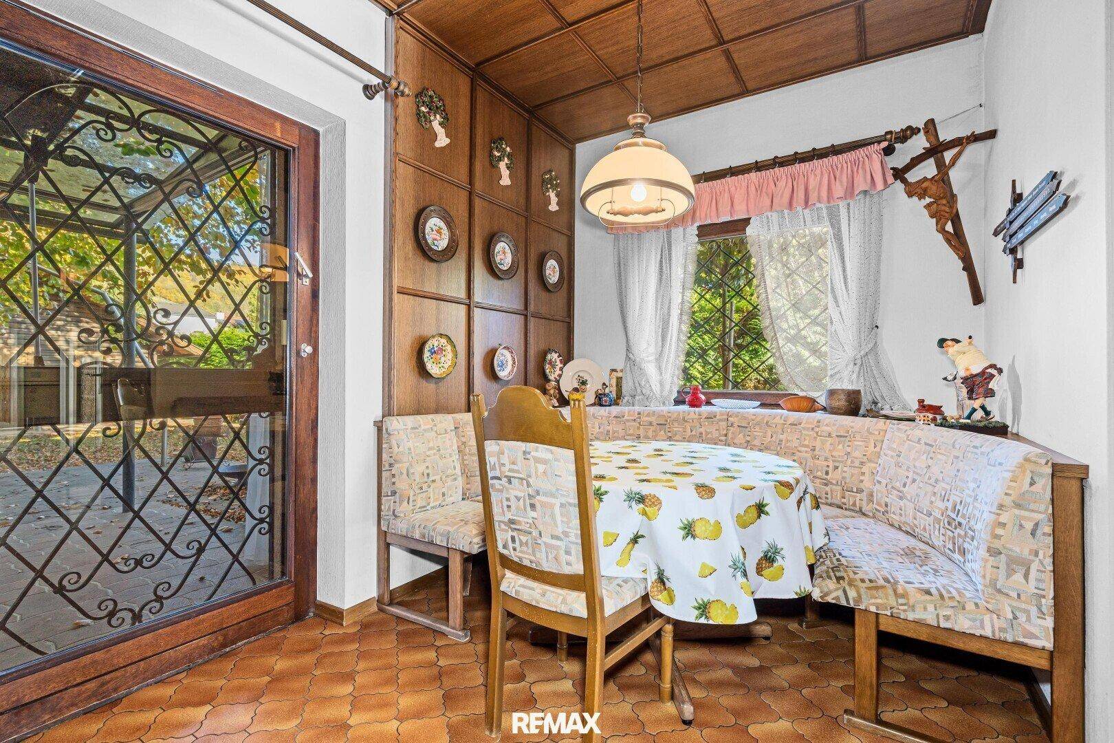 Gemütliche Essecke mit Holztäfelung, Eckbank und traditionellen Dekorationen.