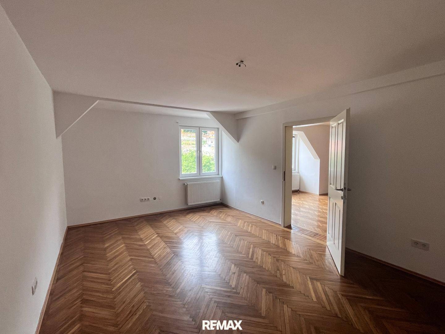 Helles Schlafzimmer mit Fischgrätparkett und Dachschräge, bereit zur individuellen Gestaltung.