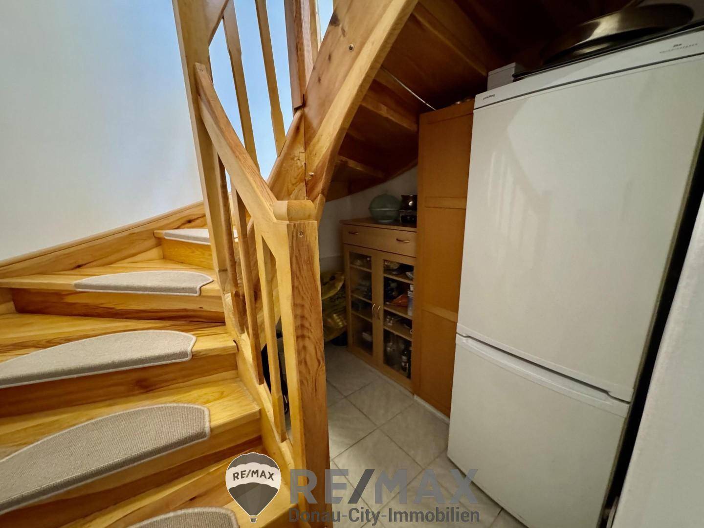 Holztreppe zum Obergeschoss mit Teppichstufen und integriertem Stauraum.