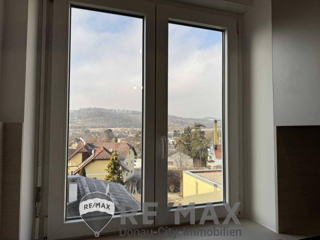 Weitblick aus dem Fenster über die Dächer der Stadt und die umliegende Landschaft.