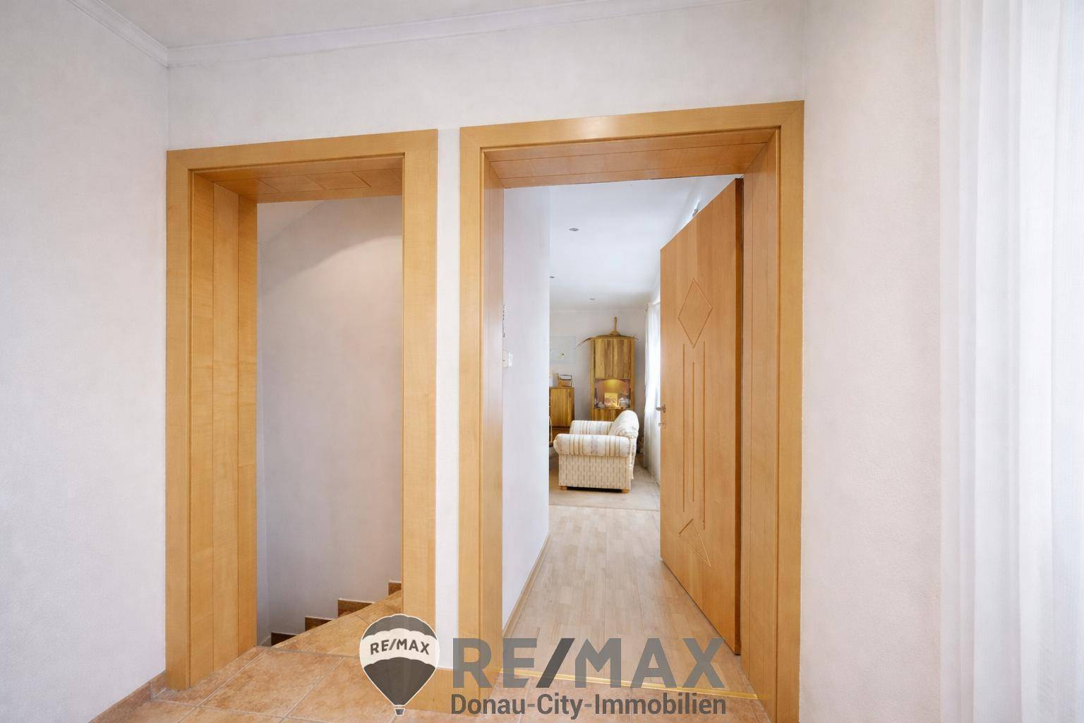 Heller Flurbereich mit Holztüren und Parkettboden, der zu weiteren Räumen führt.