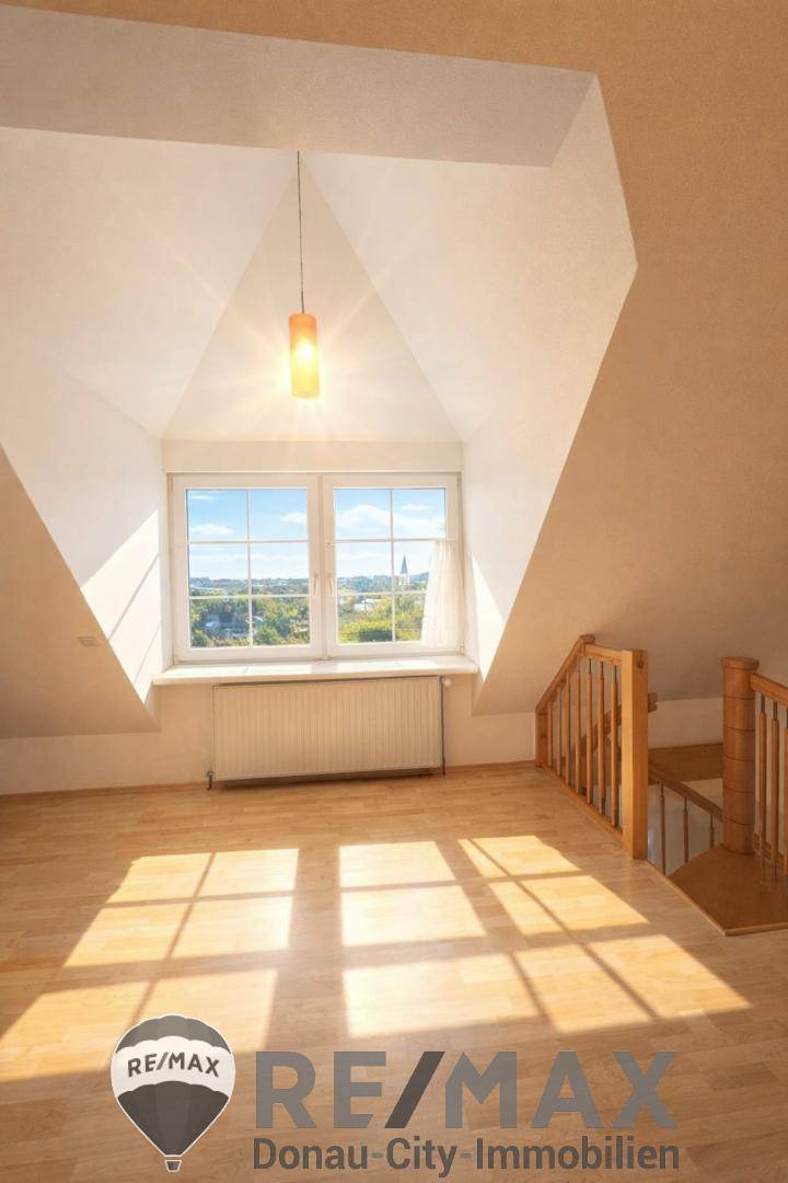 Lichtdurchfluteter Raum mit hoher, spitzer Decke und großem Fenster, ideal für ein Atelier.