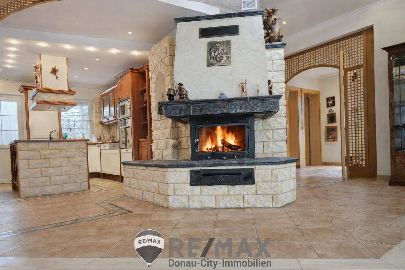 Geräumiger Wohnbereich mit großem Kamin als Mittelpunkt und gefliestem Boden.