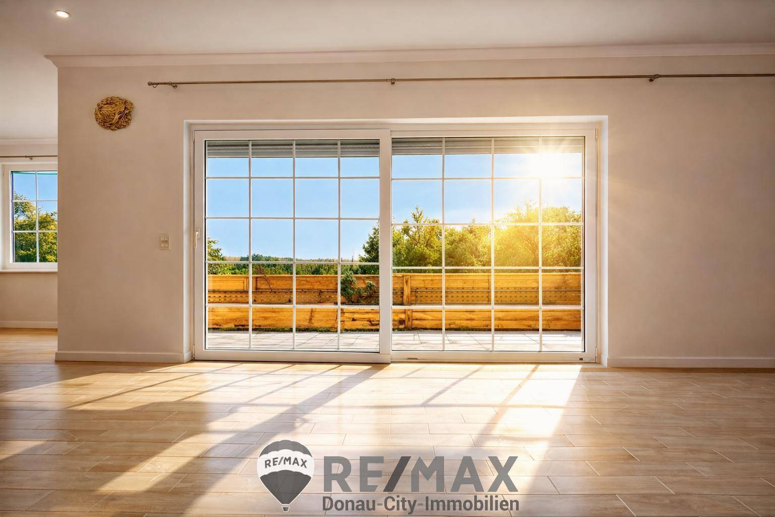 Lichtdurchfluteter Raum mit großer Schiebetür, die Zugang zu einem Außenbereich bietet.