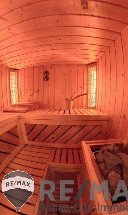 Traditionelle Holzsauna mit mehreren Bänken und Heizofen, bereit zur Entspannung.