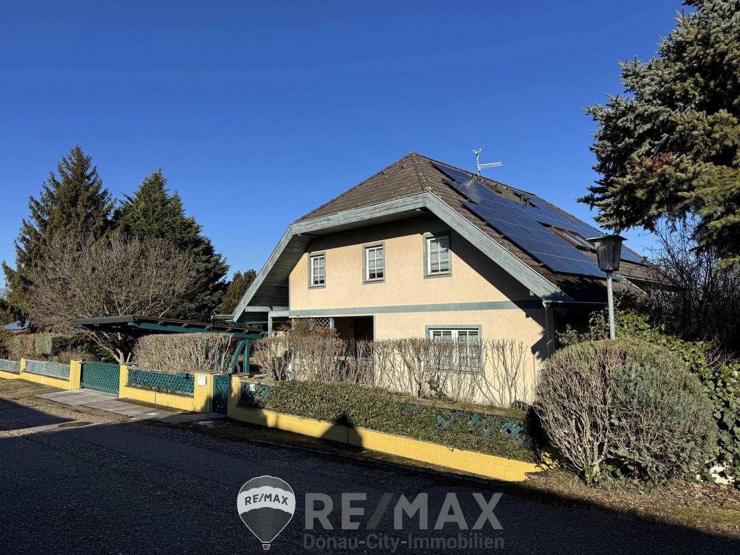 Einfamilienhaus mit Solaranlage auf dem Dach, Carport und gepflegtem Vorgarten.