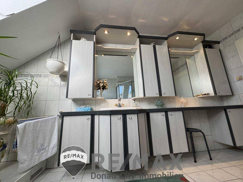 Badezimmer mit Doppelwaschbecken, Spiegelschränken und viel Stauraum in den Unterschränken.