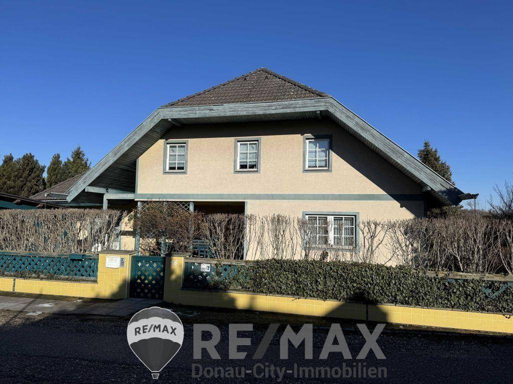 Vorderansicht des Einfamilienhauses von der Straße aus mit gepflegter Hecke.