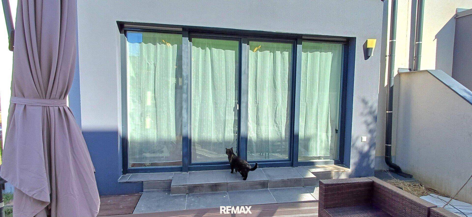Große Glasschiebetüren führen von der Terrasse ins Innere des Hauses.